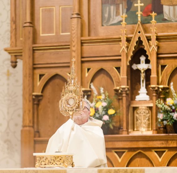 Priest holding a monstrance during Eucharistic Adoration at the Basilica of Saint Mary of the Assumption